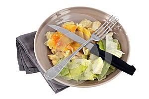 Homemade tartiflette served in a plate with cutlery close-up on a white background