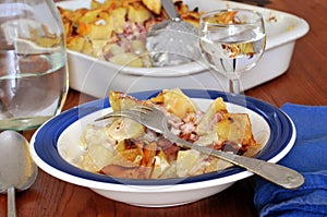 Homemade tartiflette served on a plate with a fork close-up