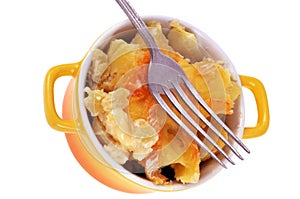 Homemade tartiflette served in a small yellow casserole dish close-up on a white background