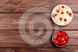 Homemade tasty fermented milk products on plates - sauerkraut, pickled tomatoes, on wooden background, copy space