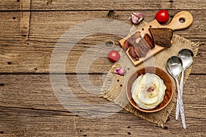 Homemade Thanksgiving garlic mashed potatoes with fresh tomatoes and pastrami. Sackcloth napkin, spoons, old wooden boards