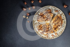 Homemade thin crepes with chocolate spread, banana and hazelnuts. breakfast or dessert. banner, menu, recipe place for text, top