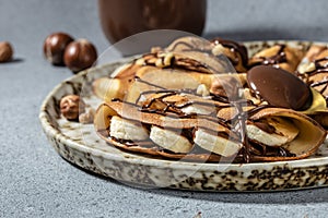 Homemade thin crepes with chocolate spread, banana and hazelnuts. breakfast or dessert. banner, menu, recipe place for text, top