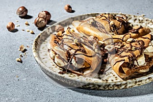 Homemade thin crepes with chocolate spread, banana and hazelnuts. breakfast or dessert. banner, menu, recipe place for text, top