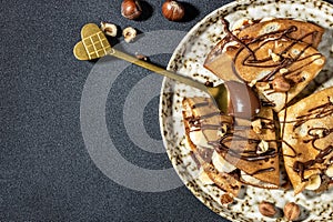 Homemade thin crepes with chocolate spread, banana and hazelnuts. breakfast or dessert. banner, menu, recipe place for text, top