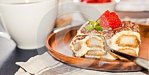 Homemade tiramisu cake decorated with strawberries Italian cuisine, Selective focus