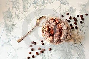 Homemade tiramisu, traditional Italian dessert in a plastic cup on a white marble background. Copy space. Top view