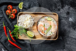 Homemade Tom Kha Gai. Coconut Milk soup in a bowl. Thai food. Black background. Top view