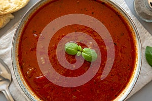 Homemade Tomato Basil Soup in a Bowl, top view. Flat lay, overhead, from above. Close-up