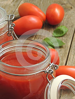 Homemade tomato souce with basil in a glass jar.