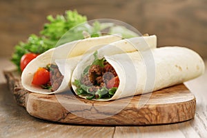 Homemade tortilla with beef, frillice and vegetables on wooden board