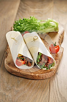 Homemade tortilla with beef, frillice and vegetables on wooden board