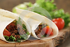 Homemade tortilla with beef, frillice and vegetables on wooden board