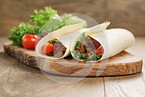 Homemade tortilla with beef, frillice and vegetables on wooden board