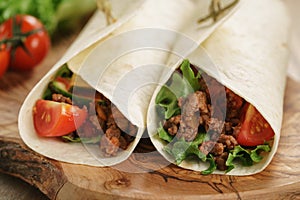 Homemade tortilla with beef, frillice and vegetables on wooden board