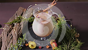 Homemade traditional Christmas eggnog drink in glasses with ground nutmeg, cinnamon and decorating with christmas tree