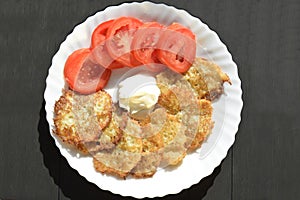 Homemade traditional fried potato pancakes with sour cream.