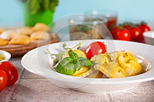 Homemade traditional italian ravioli pasta with basil and tomato cherry vegetables on the table