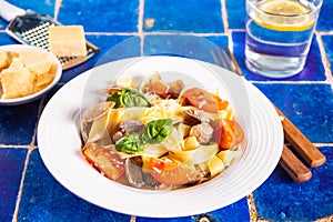 Homemade traditional italian ravioli pasta with basil and tomato cherry vegetables on the table