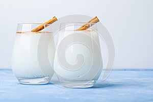 Homemade traditional mexican or spanish rice Horchata in a glass on blue background. Fresh cool summer drink or cocktail made from
