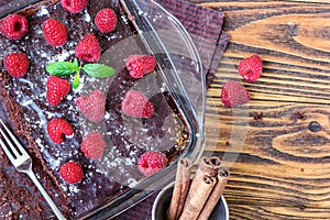 Homemade traditional sweet delicious dark chocolate brownies pie tart cake with chocolate glaze raspberries fruit green mint leave