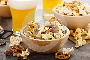 Homemade trail or snack mix with popcorn, pretzels and nuts with beer