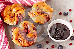 Homemade twisted rolls with blueberries sauce