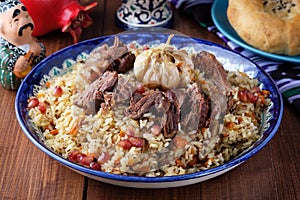 Homemade Uzbek pilaf from lamb served in cast iron cookware.