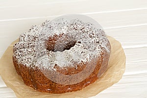 Homemade vanilla bunt cake on white wooden desk.