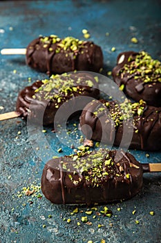 Homemade vanilla ice cream with chocolate glaze and pistachios