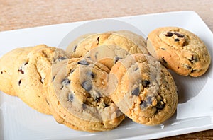 Homemade vanilla, orange, lemon chocolate chip cookies biscuits stack on a white plate