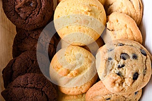 Homemade vanilla, orange, lemon chocolate chip cookies biscuits stack on a white plate