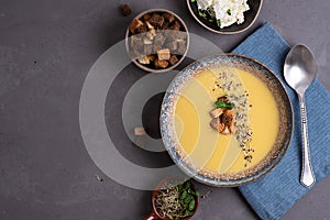 Homemade vegetarian squash cream soup with croutons and microgreens, healthy food concept