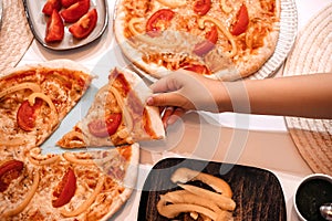 Homemade vegeterian pizza with cheese, tomatoes and pepper on kitchen table.