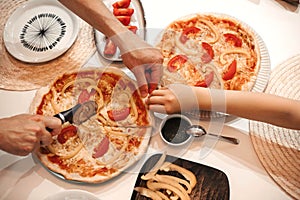 Homemade vegeterian pizza with cheese, tomatoes and pepper on kitchen table.