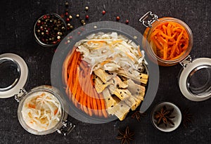 Homemade village fermented sauerkrauts, and korean carrot, asparagus. Vegan salad in black ceramic bowl. Probiotics gut health