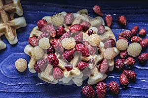 Homemade waffles with berries on blue wooden background. Delicious, nutritious, fantastic breakfast or desser