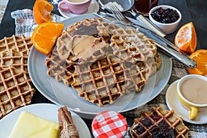 Homemade waffles with blueberry jam and peanut butter.