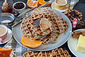 Homemade waffles with blueberry jam and peanut butter.