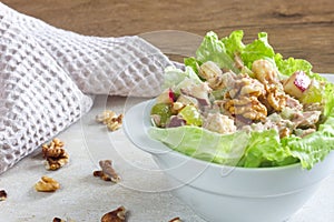 Homemade waldorf salad made of celery, apples and walnuts, served on a bed of fresh leaf lettuce