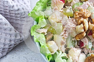 Homemade waldorf salad made of celery, apples and walnuts, served on a bed of fresh leaf lettuce