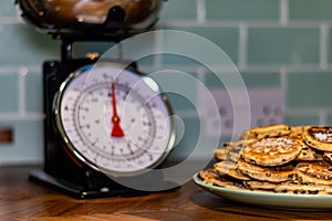Homemade Welsh Cakes Bakestones isolated on green plate with weighing scales in Background blured out