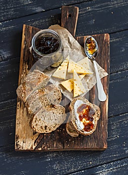 Homemade whole grain bread, cheese and figs jam. Delicious breakfast or snack.