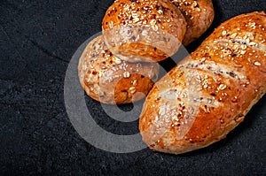 Homemade Wholemeal Multigrain Bread and Buns with Flax Seeds and Sesame on Dark Table. Top View Flat Lay. Copy Space