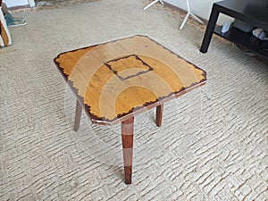 Homemade wooden three-legged magazine table
