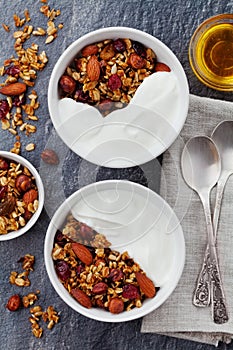 Homemade yogurt bowl with granola on black table, healthy and diet breakfast, from above