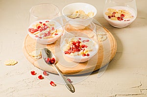 Homemade yogurt with garnet grains and flakes in glass/Homemade yogurt with garnet grains and flakes in glass on a wooden tray and