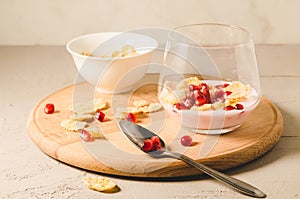 Homemade yogurt with garnet grains and flakes in glass/Homemade yogurt with garnet grains and flakes in glass on a wooden tray and