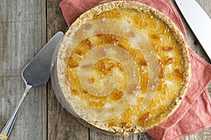 Homemadewhole lemon pie or tart with citrus jam, on a wooden background.