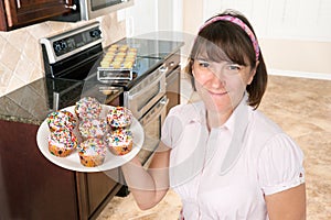 Homemaker holding plate of cupcakes